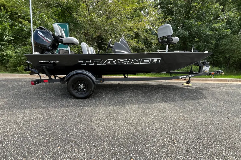 The Image of 2027 Tracker Pro 170 boat on trailer, parked outdoors with trees in background. - 0