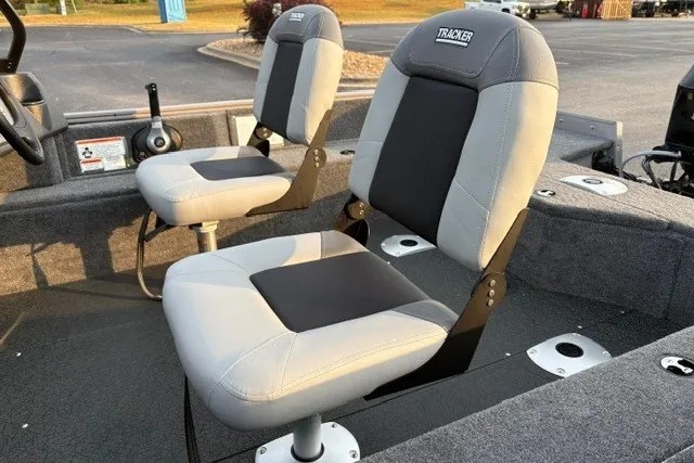 Slide: The Image of 2027 Tracker Pro Guide V-16 WT boat seats, gray and black, in a parking lot setting. - 22