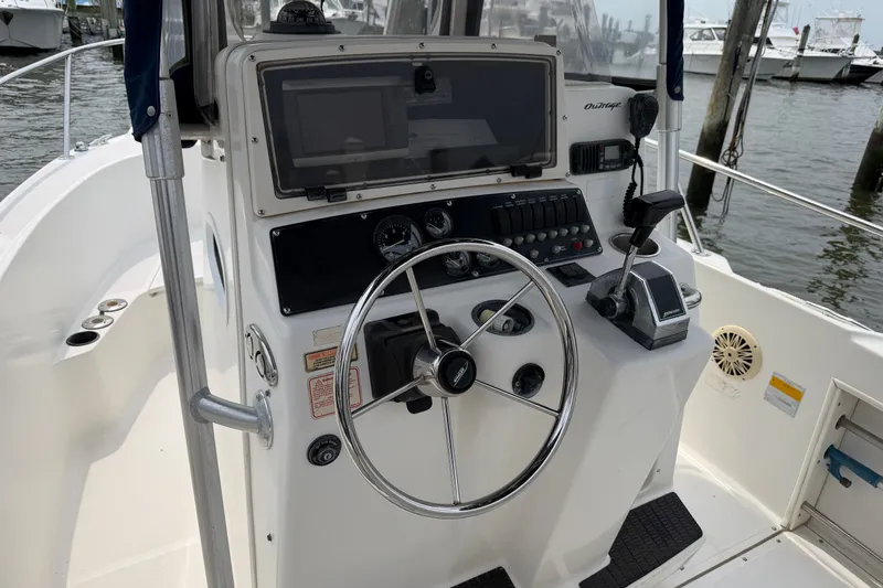Slide: The Image of 2002 Boston Whaler 210 Outrage boat console with steering wheel and controls. - 15
