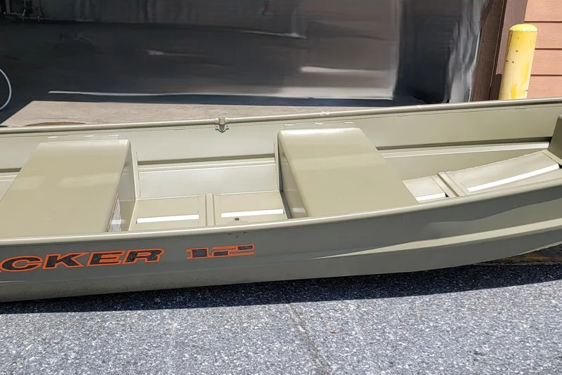 The Image of 2027 Tracker Grizzly 12 Jon boat in a garage setting, showcasing its sturdy design. - 0