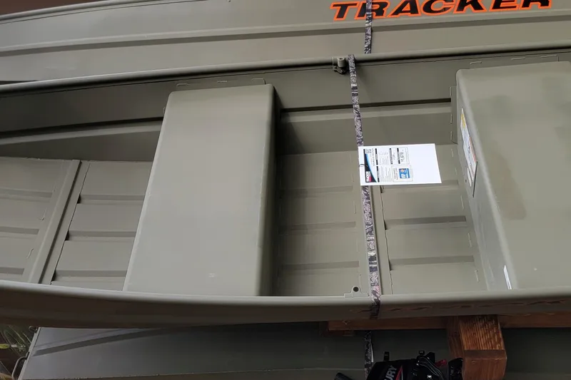 The Image of 2027 Tracker Grizzly 12 Jon boat, olive green, displayed on wooden supports. - 0