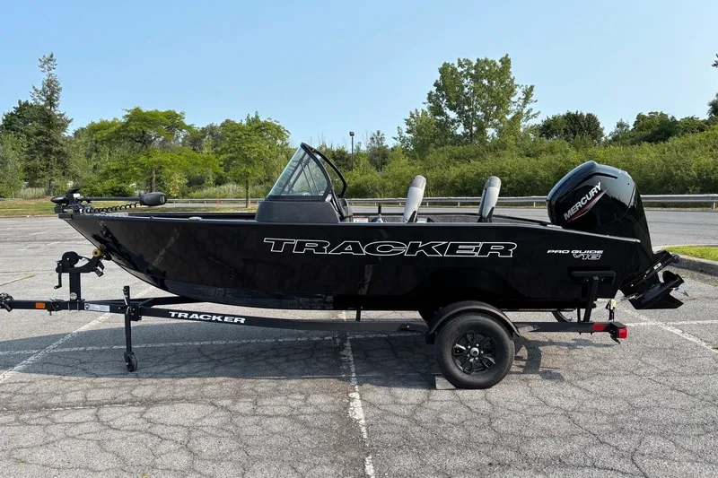 The Image of 2027 Tracker Pro Guide V-16 WT boat on trailer in parking lot. - 0