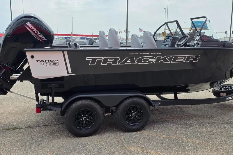 Slide: The Image of 2027 Tracker Targa V-18 Combo boat on trailer, featuring sleek black design and Mercury engine. - 35