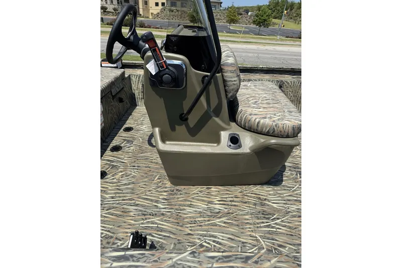 Slide: The Image of 2027 Tracker Grizzly 1860 CC boat interior with camo seating and steering console. - 70