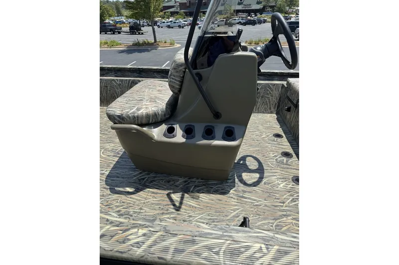 Slide: The Image of 2027 Tracker Grizzly 1860 CC boat interior with camouflage seating and steering console. - 69