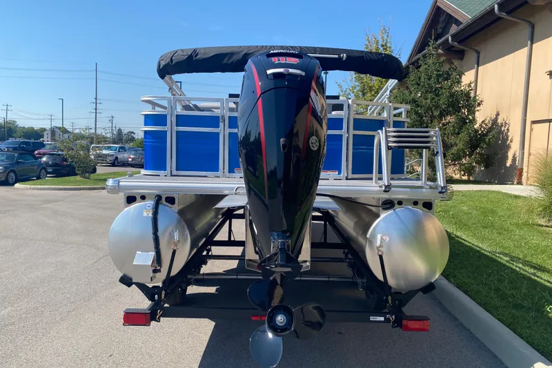 Slide: The Image of 2027 Sun Tracker SportFish 22 DLX pontoon boat with outboard motor, parked outdoors. - 13