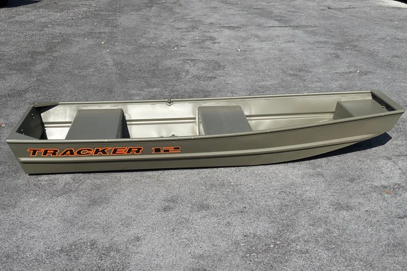 The Image of 2027 Tracker Grizzly 12 Jon boat on asphalt, showcasing durable design and spacious interior. - 0