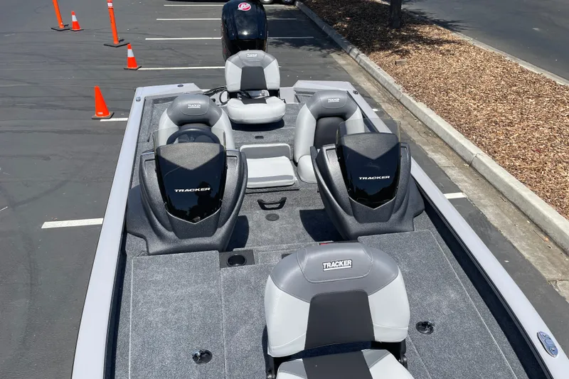 Slide: The Image of 2027 Tracker Pro Team 190 boat parked, showcasing seating and motor in a lot. - 25