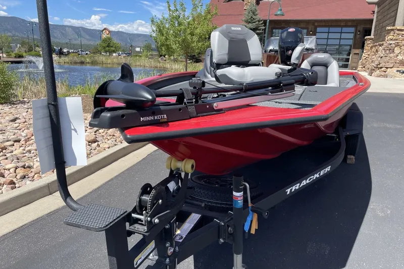 Slide: The Image of 2027 Tracker Pro Team 195 boat with Minn Kota motor, parked near a scenic pond. - 48
