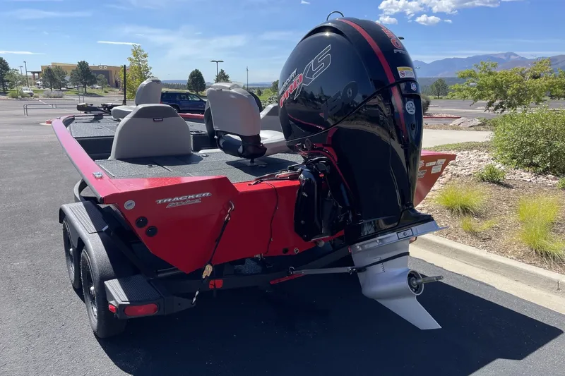 Slide: The Image of 2027 Tracker Pro Team 195 boat with powerful outboard motor in a parking lot. - 19