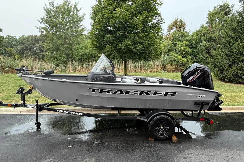 The Image of 2027 Tracker Pro Guide V-16 WT boat on trailer, parked outdoors. - 0