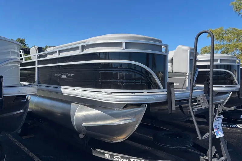 The Image of 2027 Sun Tracker SportFish 22 DLX pontoon boat displayed outdoors. - 0