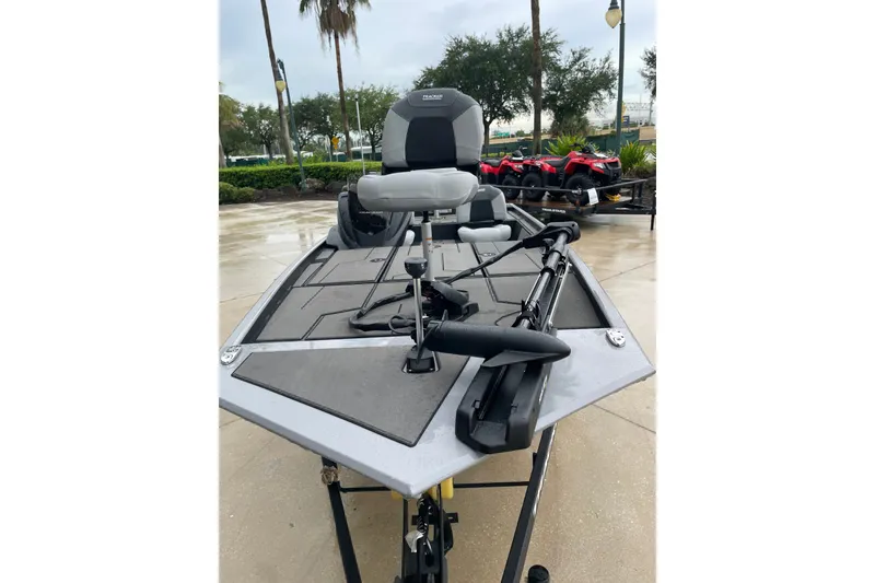 The Image of 2027 Tracker Pro 170 boat with seating and equipment, displayed outdoors on a wet surface. - 0