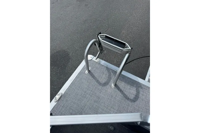 Slide: The Image of 2027 Sun Tracker SportFish 22 DLX boat ladder on deck, gray flooring. - 21