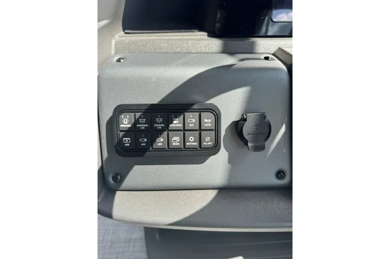 Slide: The Image of Control panel of 2027 Sun Tracker SportFish 22 DLX boat with various switches. - 17