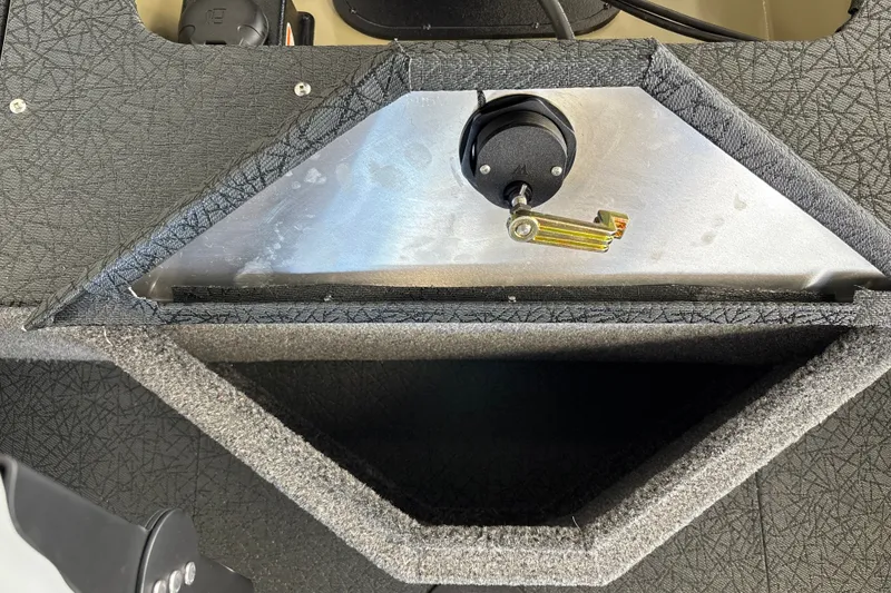 Slide: The Image of 2027 Tracker Pro Guide V-16 WT boat compartment with textured interior and latch mechanism. - 30