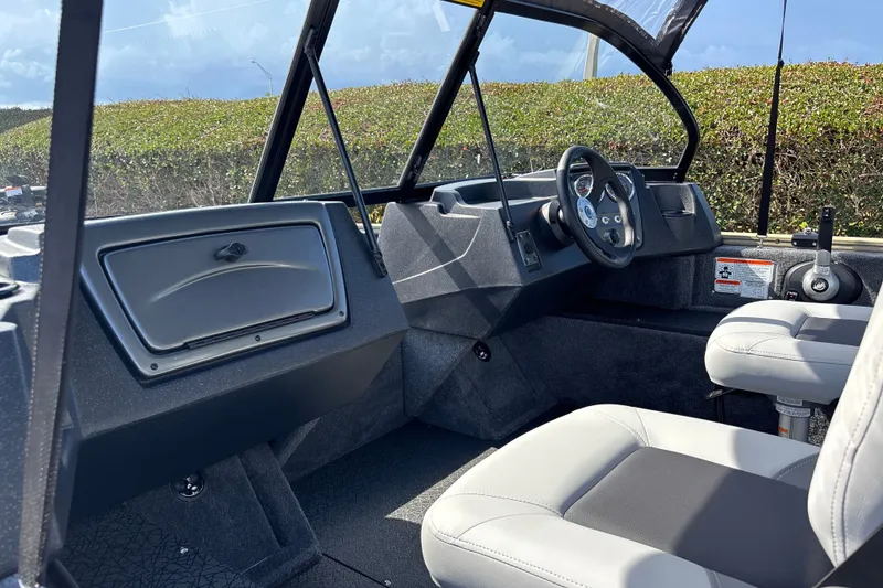 Slide: The Image of 2027 Tracker Pro Guide V-16 WT boat interior with steering wheel and seating. - 13