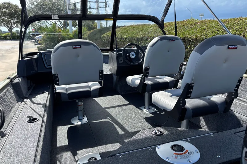 Slide: The Image of 2027 Tracker Pro Guide V-16 WT boat interior with two gray seats and steering wheel. - 16