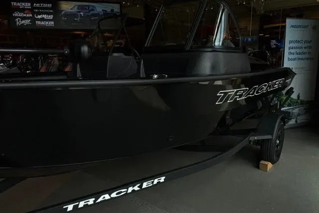 Slide: The Image of 2027 Tracker Pro Guide V-16 WT boat displayed in showroom, highlighting sleek black design. - 39