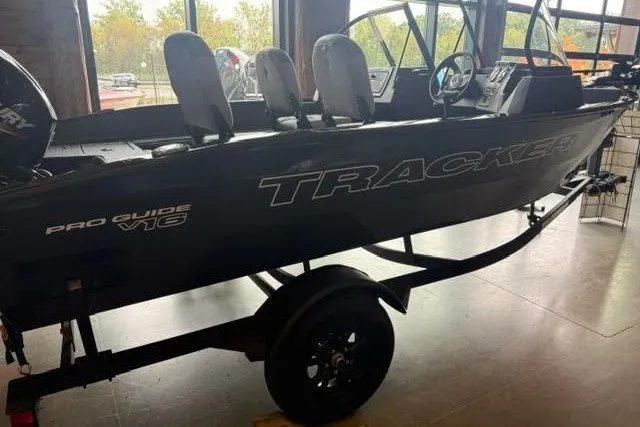The Image of 2027 Tracker Pro Guide V-16 WT boat displayed indoors on a trailer. - 0