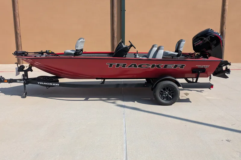 The Image of 2027 Tracker Pro Team 195 boat on trailer, red exterior, parked outdoors. - 0