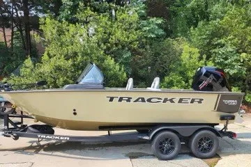 The Image of 2027 Tracker Targa V-18 Combo boat on trailer, surrounded by lush greenery. - 0