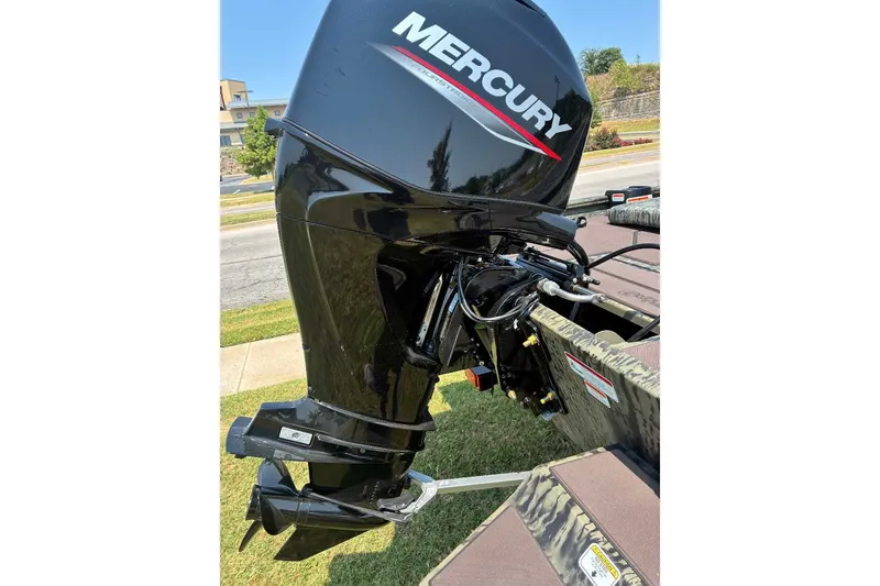 Slide: The Image of 2027 Tracker Grizzly 1860 CC with Mercury outboard motor, parked on grass. - 13