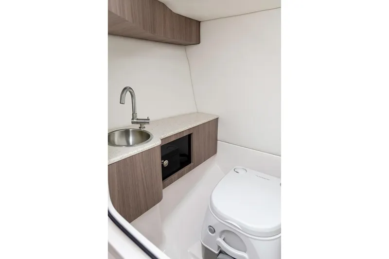 Slide: The Image of Manufacturer Provided Image: 2026 Regal LS6 boat interior with compact bathroom, featuring a sink and toilet. - 15
