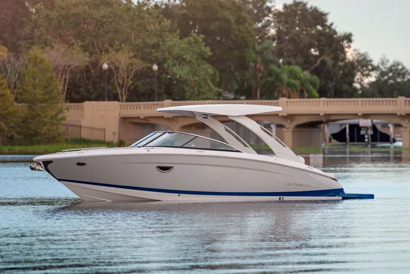 The Image of Manufacturer Provided Image: 2026 Regal LS9 boat on calm water near a bridge, surrounded by trees. - 0