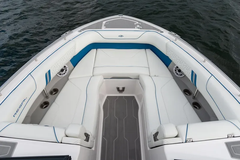 Slide: The Image of Manufacturer Provided Image: 2026 Regal LS9 boat interior with white and blue seating, on calm water. - 3