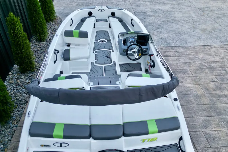 Slide: The Image of 2022 Tahoe T18 boat interior with green accents, steering wheel, and seating. - 6