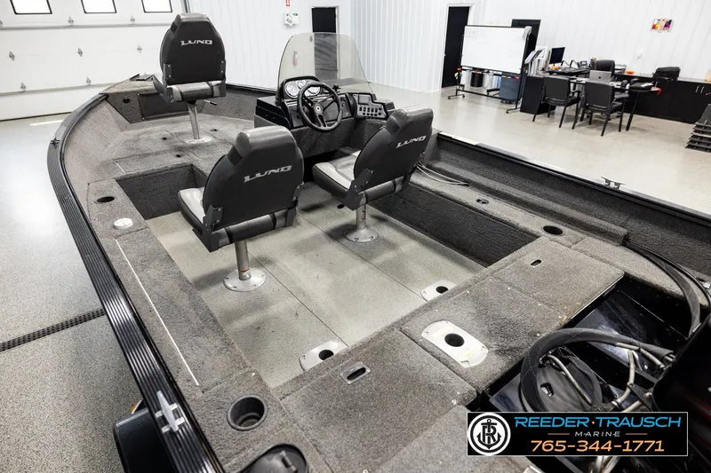 Slide: The Image of 2017 Lund 1650 Rebel XS SS boat interior with seating and steering wheel in showroom. - 9