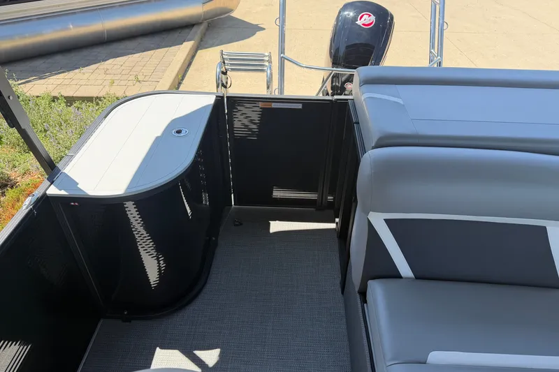 Slide: The Image of 2025 Crest Classic 200 pontoon boat interior with seating and motor view. - 17