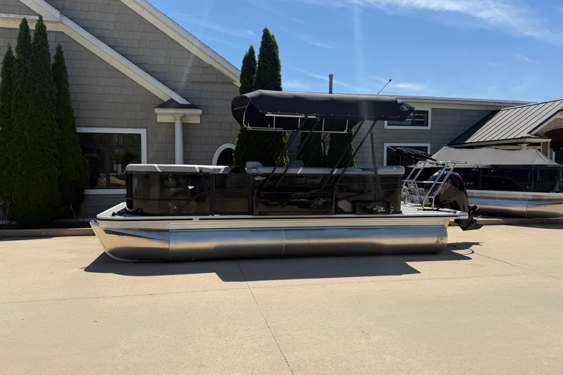 The Image of 2025 Crest Classic 200 pontoon boat parked outside a building on a sunny day. - 0