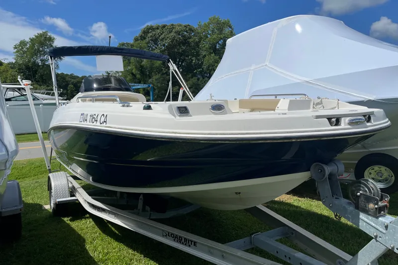 Slide: The Image of 2017 Stingray 192 SC boat on trailer, parked outdoors under a clear blue sky. - 15