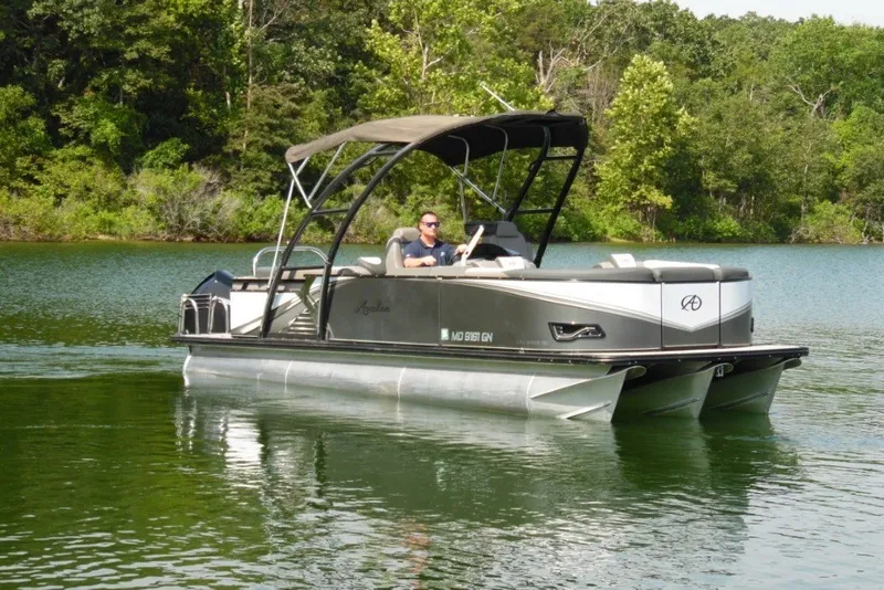 The Image of 2021 Avalon LSZ Quad Lounge 24' pontoon boat cruising on a serene lake. - 0