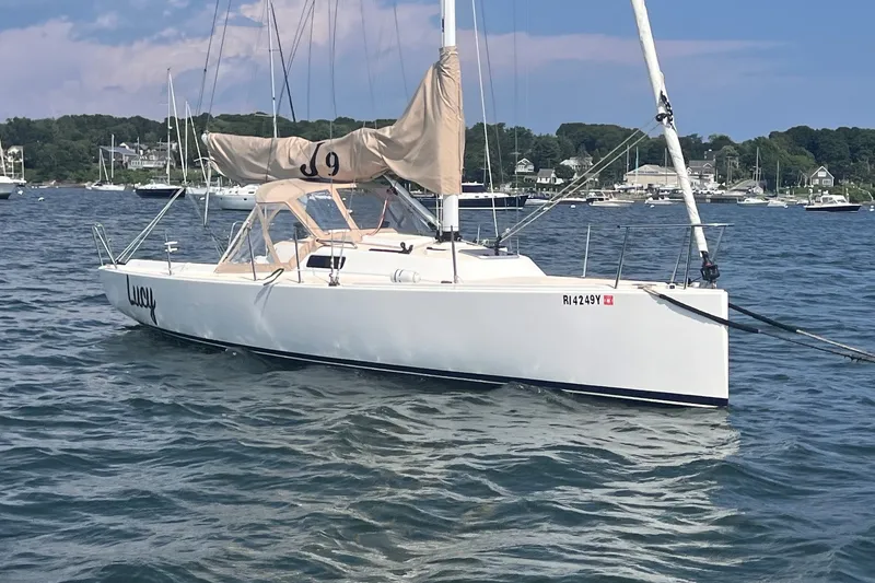 Slide: The Image of 2023 J Boats J/9 sailboat named Lucy on calm water, scenic background. - 3