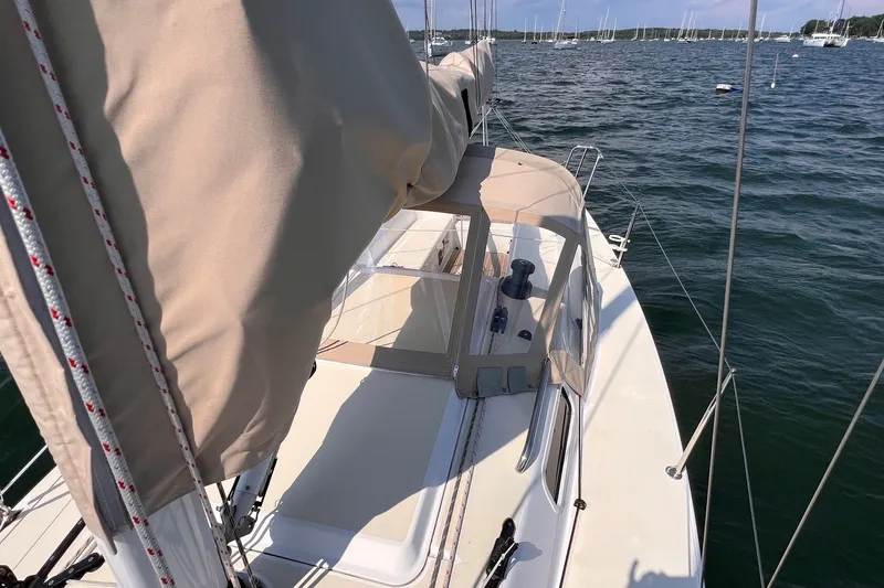 Slide: The Image of 2023 J Boats J/9 sailboat on calm water, featuring beige sail cover and deck details. - 12