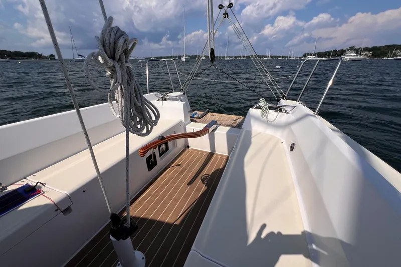 Slide: The Image of 2023 J Boats J/9 sailboat cockpit with ropes, wooden deck, and scenic water view. - 15