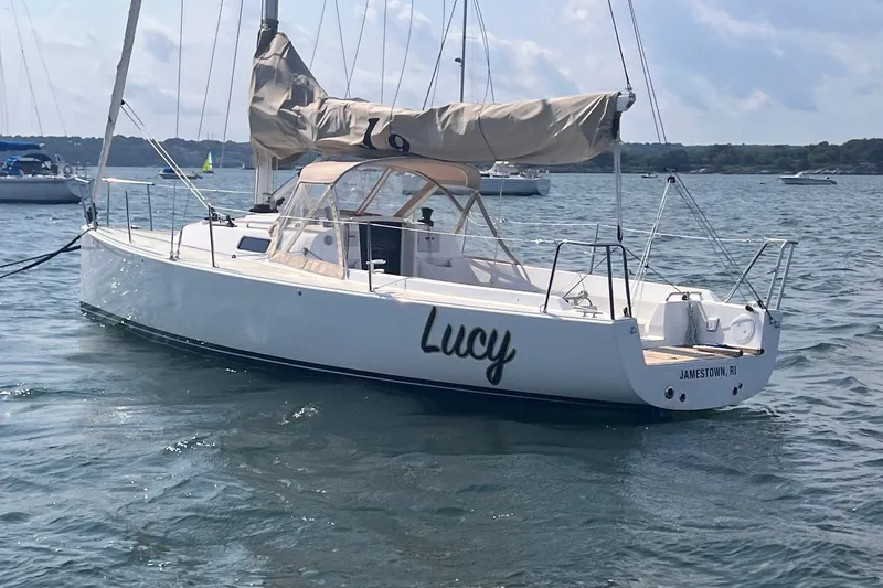 Slide: The Image of 2023 J Boats J/9 sailboat named "Lucy" anchored in calm waters. - 4