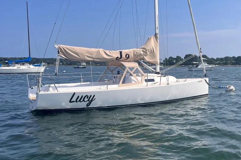 Slide: The Image of 2023 J Boats J/9 sailboat named "Lucy" anchored on calm water. - 1