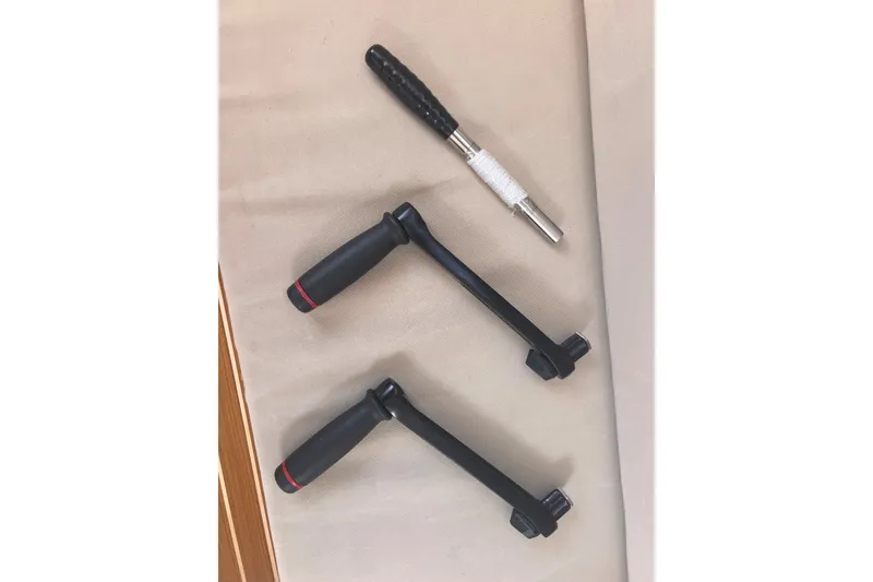 Slide: The Image of Three black winch handles for J Boats J/9, 2023 model, on a beige surface. - 38