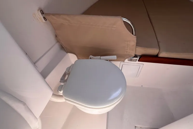 Slide: The Image of 2023 J Boats J/9 interior with compact marine toilet and beige seating. - 36
