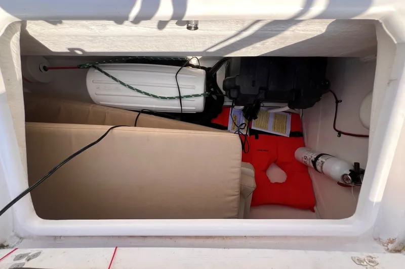 Slide: The Image of Storage compartment of 2023 J Boats J/9 with life jacket, fire extinguisher, and cushions. - 21