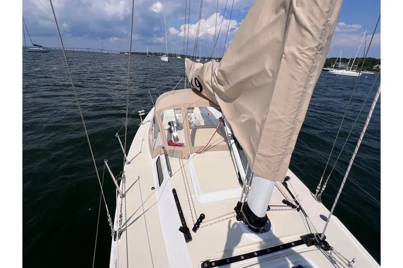 Slide: The Image of 2023 J Boats J/9 sailboat on calm waters under a partly cloudy sky. - 11