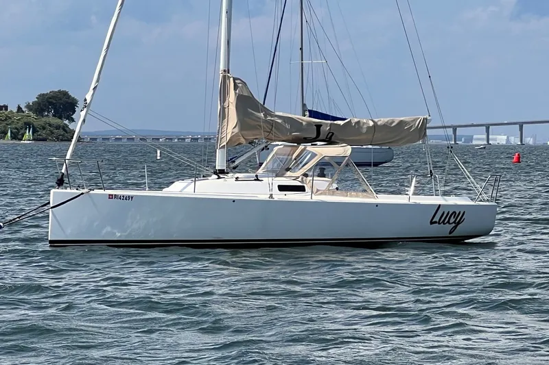 Slide: The Image of 2023 J Boats J/9 sailboat named Lucy on calm water with bridge in background. - 6