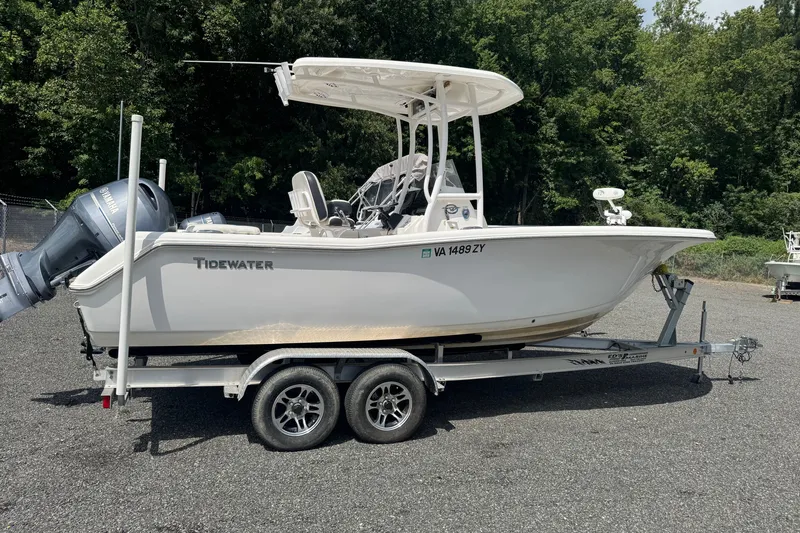 The Image of 2021 Tidewater 220 LXF boat on trailer, parked outdoors with lush green background. - 0