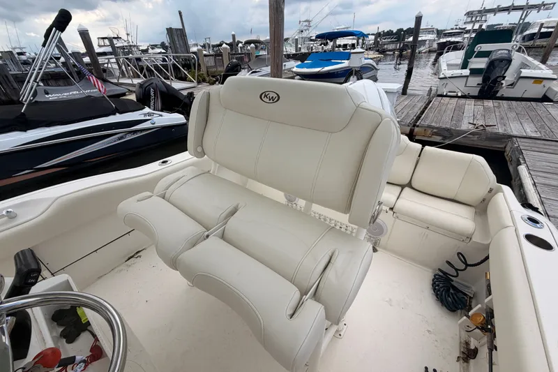 Slide: The Image of 2021 Key West 219 FS boat interior with white seating at a marina dock. - 13
