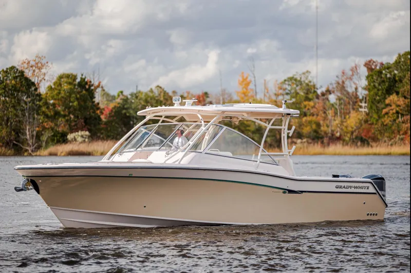The Image of 2013 Grady-White Freedom 335 boat cruising on a scenic lake with autumn foliage. - 1
