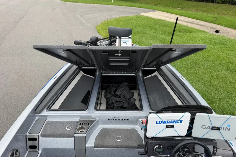 Slide: The Image of 2022 Falcon F20 boat with open storage compartments and navigation equipment on a grassy roadside. - 8